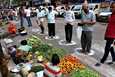 Vihanneskaupoille tulleet ihmiset odottivat vuoroaan maahan piirrettyjen ympyröiden sisällä välttääkseen lähikontaktia Intian Kolkatassa keskiviikkona.