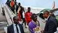 Norsunluurannikon pääministeri Patrick Achi (oike.) toivotti Tunisiasta paluulennolla kotiutettuja ihmisiä Abidjanin kaupungissa lauantaina.