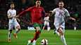 Portugalin Cristiano Ronaldo kuljettaa palloa Pohjois-Makedonian pelaajien välistä. 