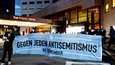 Ihmiset osoittivat tiistaina mieltään Leipzigissä sijaitsevan hotellin edustalla antisemitismiä vastaan.