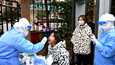 Työntekijä otti nielunäytteen koronavirustestiä varten Lanzhoun kaupungissa keskiviikkona 20. lokakuuta.