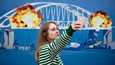 Девушка делает селфи на фоне гигантской почтовой марки с изображением взорванного Крымского моста. Киев. Октябрь 2022 года. Фото: Алексей Чумаченко / Sopa Images