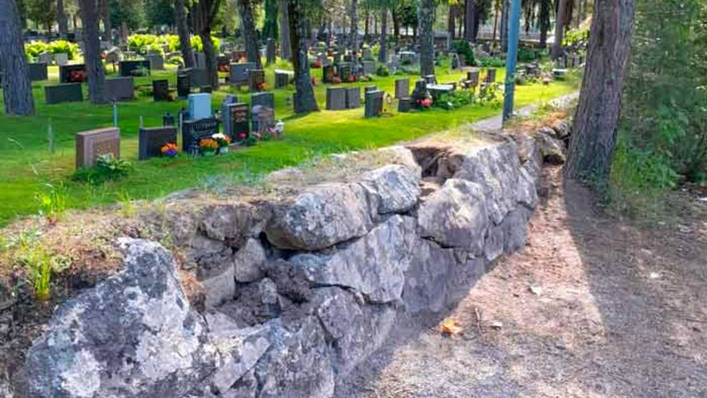 Ilkivalta | Hautausmaan historiallinen kiviaita joutui ilkivallan kohteeksi: kiviä on irrotettu ja vieritetty läheiseen lampeen Vantaalla