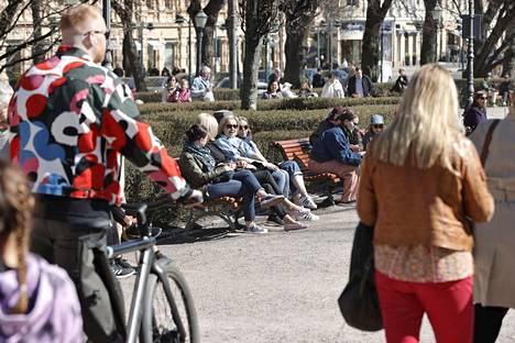 Ihmiset nauttivat aurinkoisesta kevätpäivästä Esplanadin puistossa Helsingissä 22. huhtikuuta.