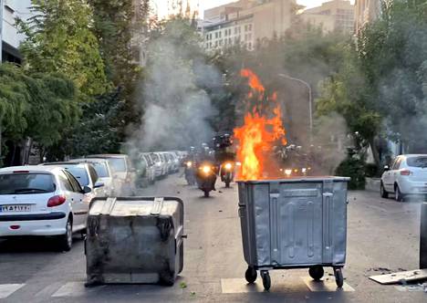 Roskapöntöt paloivat Iranin pääkaupungissa Teheranissa tiistaina mielenosoituksen aikana.