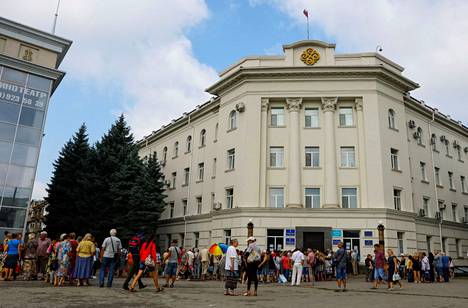 Paikallisia asukkaita hakemassa taloudellista apua Venäjän hallitsemassa Hersonin kaupungissa 25. heinäkuuta.