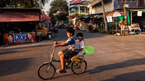 Lapset ajavat polkupyörällä lämpöaallon kurittamassa Bangkokissa toukokuun alussa.