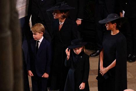 Prinssi George, 9, ja prinsessa Charlotte, 7, osallistuivat kuningatar Elisabetin hautajaisiin. Takana lasten äiti, prinsessa Catherine sekä Sussexin herttuatar Meghan.