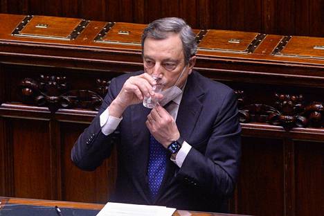 Italian pääministeri Mario Draghi raotti kasvomaskiaan juodakseen vettä senaatin salissa Roomassa 11. tammikuuta.