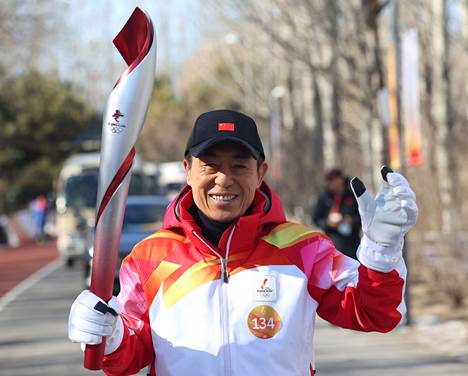 Zhang Yimou carried the Olympic torch in Beijing on Wednesday.