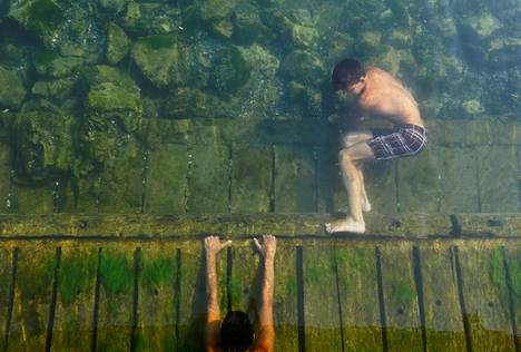 Poika viilensi oloaan uimalla joessa Makedoniassa lauantaina.
