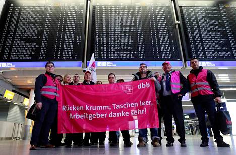 Lakkoilevat lentoasematyöntekijät esittelivät kannanottojaan Frankfurtin lentoasemalla tiistaiaamuna.