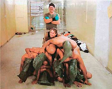 Yhdysvaltalaissotilaat Charles Graner (takana) ja Sabrina Harman poseerasivat alastomien irakilaisvankien kanssa Abu Ghraibin vankilassa 2000-luvun alussa.