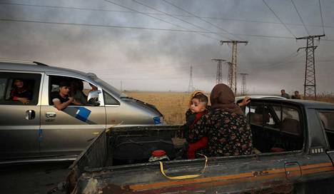 Nainen ja lapsi pakenivat Turkin hyökkäystä Ras al-Ainin rajakaupungista Syyriassa keskiviikkoiltana.