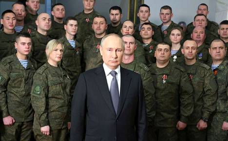 Venäjän johtajan Vladimir Putinin (edessä keskellä) uudenvuodenpuhe kuvattiin sotilasasuihin pukeutuneen ryhmän edessä. Kuvasta tuli nopeasti tunnettu, sillä siitä tunnistettiin Putinin lähellä aiemmin tavallisina ihmisinä esiintyneitä. 