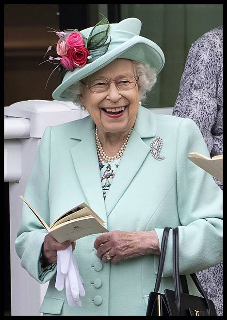 Kuningatar Elisabet kesäkuussa 2021 turkoosissa asussa. Hatun kukkakoriste myötäilee kuningattaren mekon kuviota. 