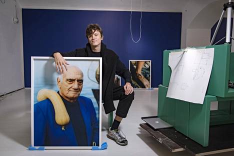 Osma Harvilahti ja Designmuseon näyttelyn pääkuva miehestä olallaan kurpitsa.