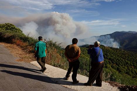 Ihmiset katsoivat palosta nousevaa savua Malagan lähettyvillä Pujerrassa.