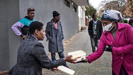 Vapaaehtoiset jakavat ruokapaketteja Johannesburgissa Etelä-Afrikassa.