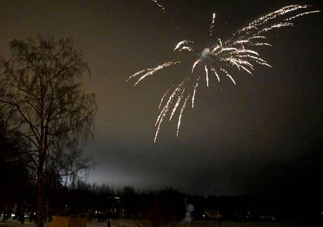 Ihmisiä ampumassa ilotulitteita uudenvuoden kunniaksi uudenvuodenaattona Lauttasaaressa Helsingissä.