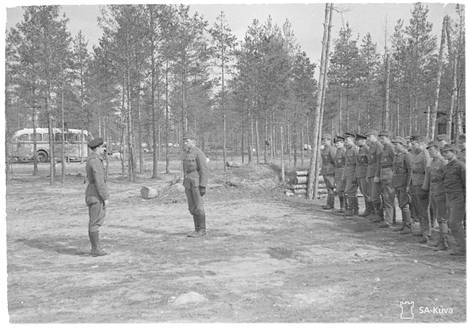 Lentueenpäällikkö ja Mannerheim-ristin ritari Jorma Karhunen (vas.) toivotti ylikersantti Katajaisen tervetulleeksi takaisin lentueeseen henkilökunnan edessä Suulajärvellä huhtikuussa 1943.