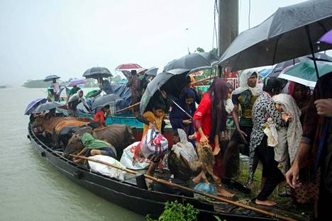 Ihmisiä evakuoitiin pelastusveneillä tulva-alueelta perjantaina Sylhetissä. 