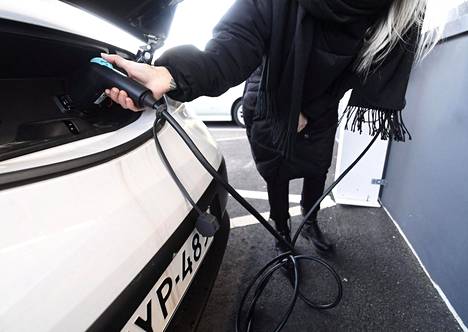 Nainen lataa Nissan Leaf -täyssähköautoa Helsingissä 22. tammikuuta 2020.