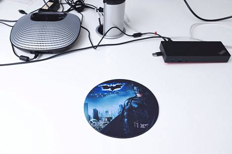 A Batman-themed mouse pad awaits the user on the conference room table.