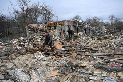Paikalliset siivoavat raunioita Lvivissä. Yksi kuolleista löydettiin romahtaneesta talosta vasta päivällä.