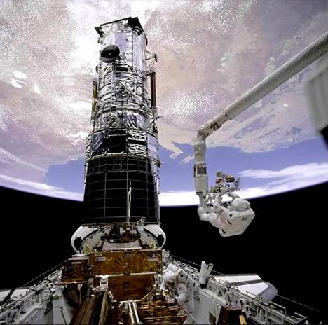 Avaruussukkula - nimeltään myöskin Endeavor - huolsi avaruusteleskooppi Hubblea  robottikäsivarrella joulukuussa 1993. Hubble pystyasennossa. 