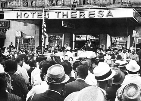 Harlem Shuffle -romaanin tapahtumiin kiinteästi liittyvä Theresa-hotelli oli 1960-luvulla yksi mustan New Yorkin merkkirakennuksia, jossa taiteilijat, aktivistit ja muutkin julkkikset asuivat ja juhlivat. Kuvassa vuodelta 1963 Arnold Johnson puhuu hotellin edustalla mielenosoittajille.
