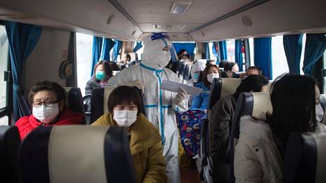 Terveiksi todettuja karanteenissa olleita potilaita kuljetettiin kotiin bussilla wuhanilaisesta sairaalasta torstaina.