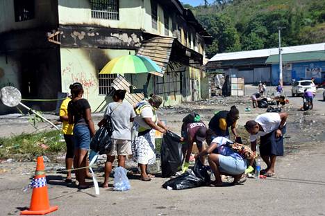 Ihmiset siivosivat mellakoinnin jälkiä Honiarassa sunnuntaina 28. marraskuuta.