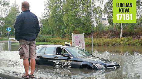 Rankkasateet aiheuttivat tulvan kadulle Espoossa, palomies kantoi upoksiin joutuneen auton matkustajat turvaan