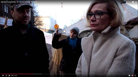 Sisäministeri Paula Risikko (kok) vieraili keskiviikkona sekä irakilaisten turvapaikanhakijoiden että heitä vastustavien mielenosoittajien leireissä Helsingin keskustassa. Kuvassa Risikko vastustajien leirissä. Kuvakaappaus Youtube-videosta.