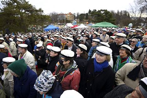 Vapunviettäjät katselevat ja kuuntelevat, kun Ylioppilaskunnan Laulajat avaa kuorolaulullaan perinteisen vappupiknikin Helsingin Kaivopuistossa.