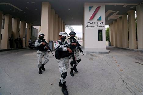 Meksikolaisia poliiseja hotellin edustalla torstaina lähellä huumejengien yhteenoton tapahtumapaikkaa.