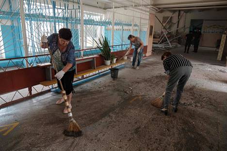 Opettajat ja muut työntekijät siivosivat pommituksesta selvinnyttä koulua Bahmutissa Donetskin alueella 24. heinäkuuta.