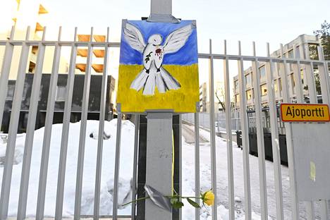 Ukrainan lipun värit rauhankyyhkyn taustalla ja keltainen ruusu Venäjän suurlähetystön edessä tiistaina.