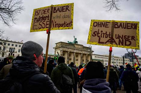 Demonstrators on Monday at the Brandenburg Gate in Berlin.  The sign on the left reads: 