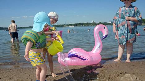 Heli Nikula kaitsi viisivuotiasta Daliaa ja kaksivuotiasta Sisua Hietaniemen uimarannalla Helsingissä 26. kesäkuuta.