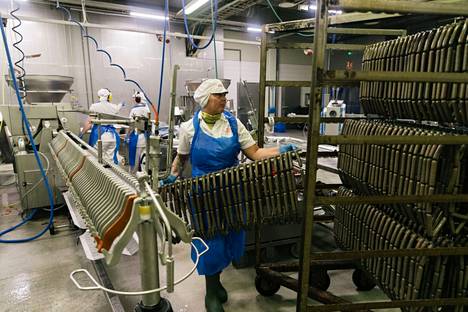 Production worker Angelika Rudnik lifts vegetable sticks to a baking cart in a spraying hall at the Poutu factory. 