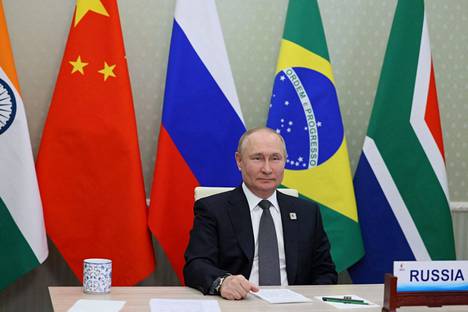 Venäjän presidentti Vladimir Putin osallistui Kremlin välittämän kuvan mukaan perjantaina Brics-ryhmän etähuippukokoukseen videoyhteydellä Moskovasta. Taustalla ovat Brics-maiden eli Intian, Kiinan, Venäjän, Brasilian ja Etelä-Afrikan liput.