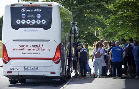 Российские путешественники садятся в автобус фирмы «Совавто». Фото: Юха Метсо
