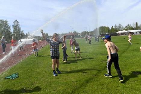Myllymäen koulun ekaluokkalaiset vilvoittelivat liikuntatunnin päätteeksi kastelulaitteen alla Mäntsälässä toukokuun 20. päivä.