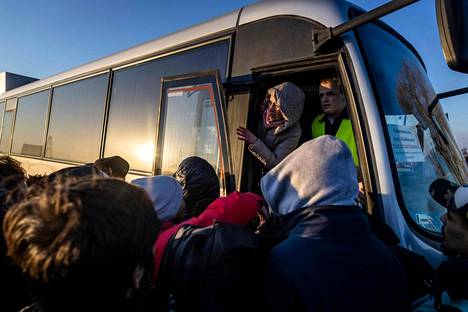 Ukrainasta pakenevat kokoontuivat bussiin maanantaina Ukrainan ja Puolan rajalla.