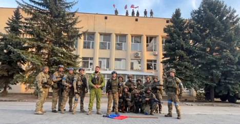 Ukrainan puolustusvoimat poseerasi Lymanin kaupunginhallinnon edessä viime lauantaina. Kuvakaappaus 1. lokakuuta julkaistulta videolta.