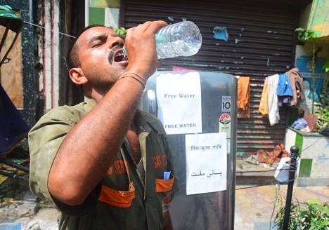 Mies juo vettä Kalkutassa Länsi-Bengalissa huhtikuussa.