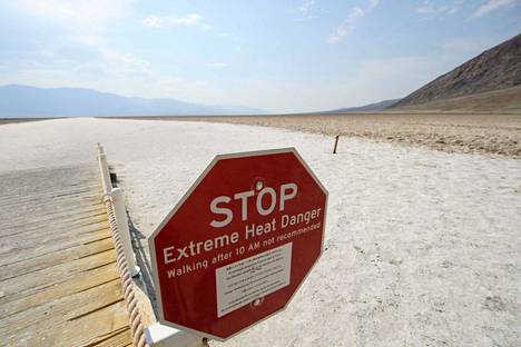 Äärimmäisestä kuumuudesta varoittava kyltti Kuolemanlaakson suola-aavikolla Badwaterin valuma-alueella Kaliforniassa. Kuva on otettu viime kesänä.