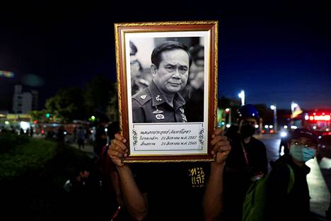 Mielenosoittaja piti käsissään pääministeri Prayut Chan-o-chan kuvaa tiistaina 23. elokuuta pääministeriä vastustavassa mielenosoituksessa.